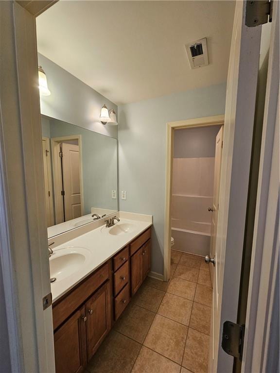 bathroom featuring double vanity, visible vents, tile patterned flooring, and a sink