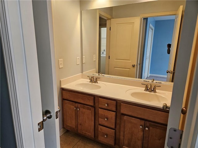 bathroom featuring tile patterned flooring, double vanity, and a sink