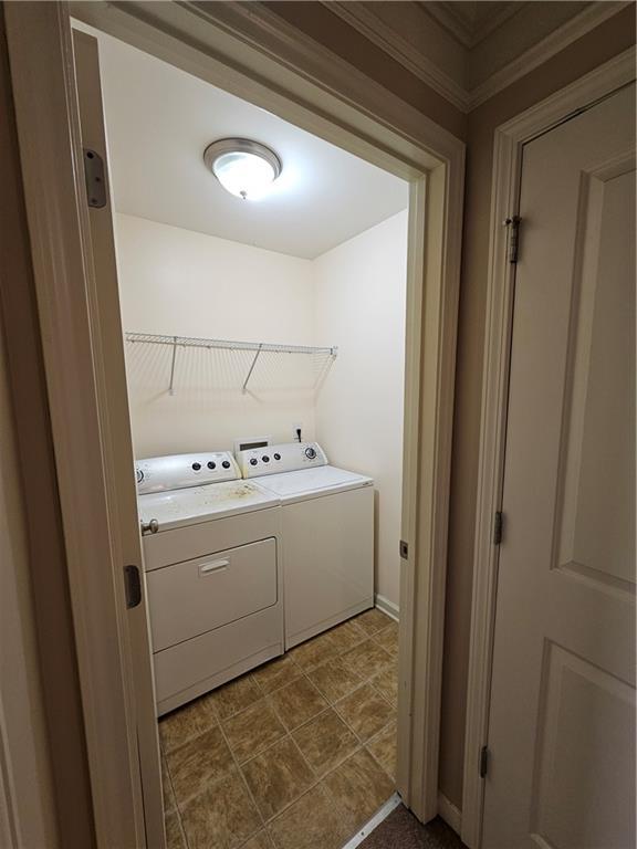 clothes washing area featuring baseboards, separate washer and dryer, and laundry area