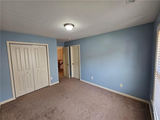 unfurnished bedroom featuring carpet flooring, baseboards, and a closet