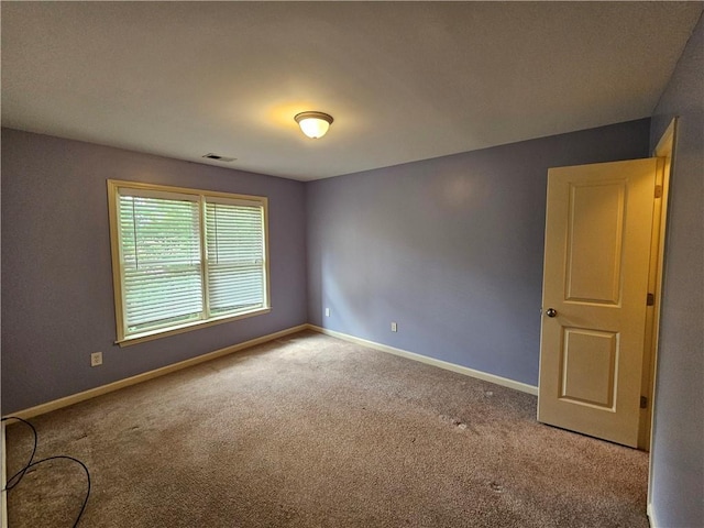 carpeted empty room with baseboards and visible vents