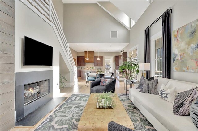150 Ray Way, Chattahoochee Hills, GA 30268 - living room with light wood finished floors, high vaulted ceiling, a glass covered fireplace, and recessed lighting