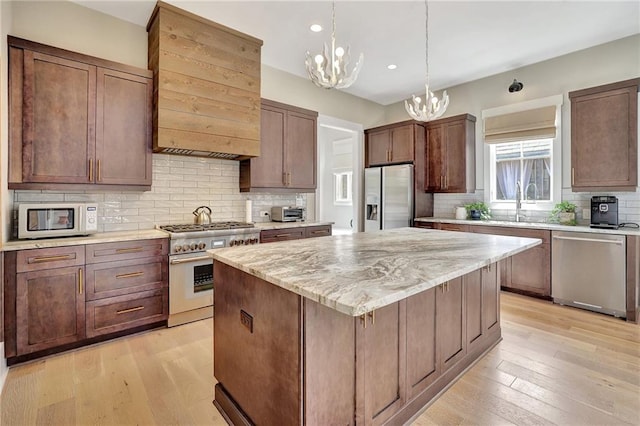 150 Ray Way, Chattahoochee Hills, GA 30268 - kitchen featuring appliances with stainless steel finishes, a chandelier, a center island, decorative backsplash, and light wood-type flooring