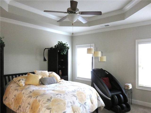 carpeted bedroom featuring a raised ceiling, ceiling fan, and ornamental molding