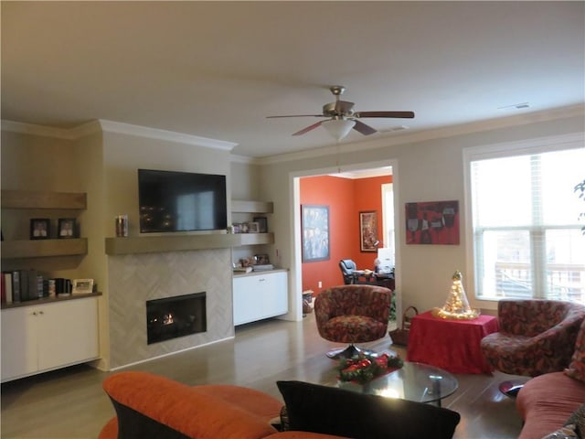 living room with crown molding, a fireplace, ceiling fan, and hardwood / wood-style flooring