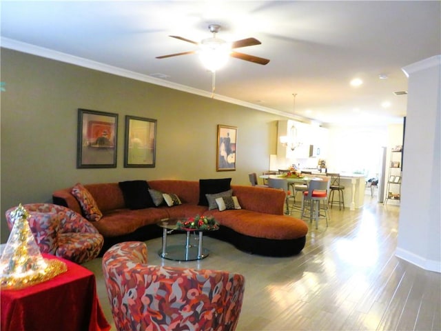 living room featuring light hardwood / wood-style floors, ceiling fan, and ornamental molding