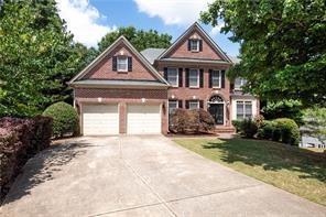 302 Shawnee Indian Ln, Suwanee, GA 30024 - view of front of home with driveway, a garage, and a front lawn