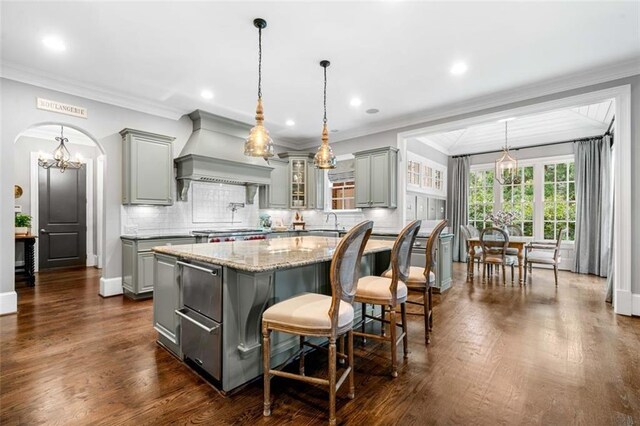 kitchen with gray cabinetry, custom exhaust hood, and a center island