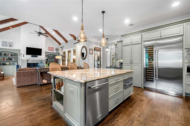kitchen featuring gray cabinets, ceiling fan, a kitchen island, vaulted ceiling with beams, and stainless steel appliances