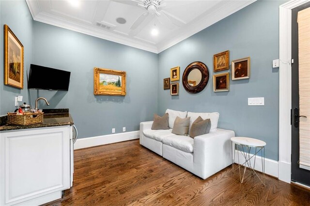living room featuring dark wood finished floors, a ceiling fan, baseboards, visible vents, and ornamental molding