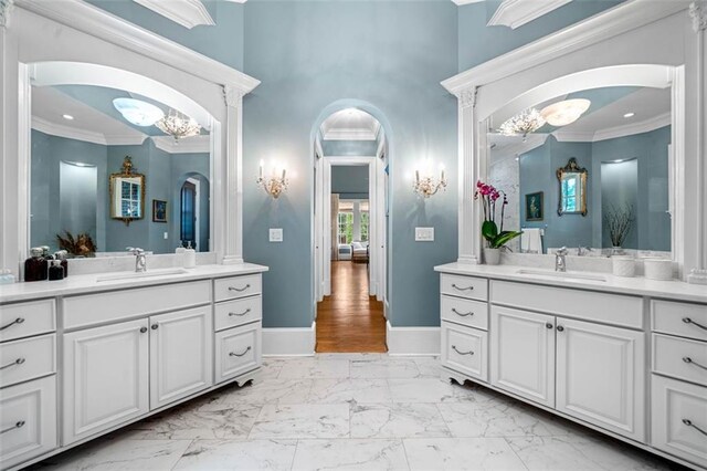 bathroom with a sink, marble finish floor, a chandelier, and ornamental molding