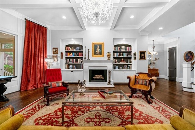 living room with crown molding, coffered ceiling, wood finished floors, and a chandelier