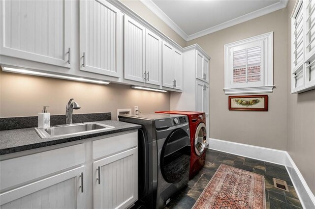 laundry area with cabinet space, baseboards, a sink, and stone tile flooring