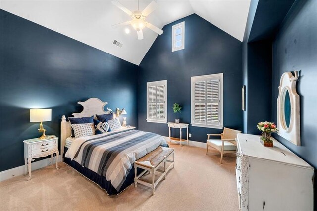 bedroom featuring a ceiling fan, light colored carpet, visible vents, baseboards, and high vaulted ceiling