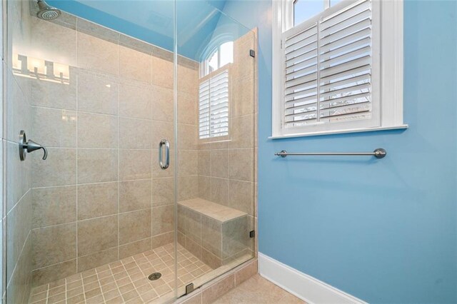 full bath with baseboards, tile patterned floors, and a stall shower