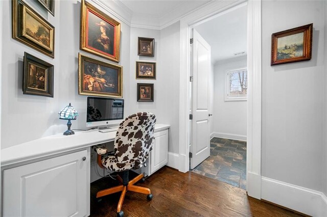 office space with crown molding, stone finish floor, and baseboards
