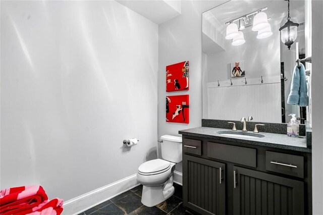 bathroom with baseboards, vanity, toilet, and marble finish floor