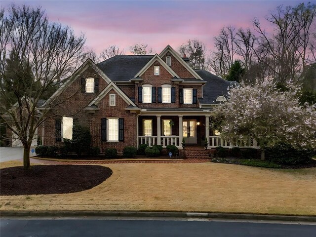 craftsman-style home featuring a porch and brick siding