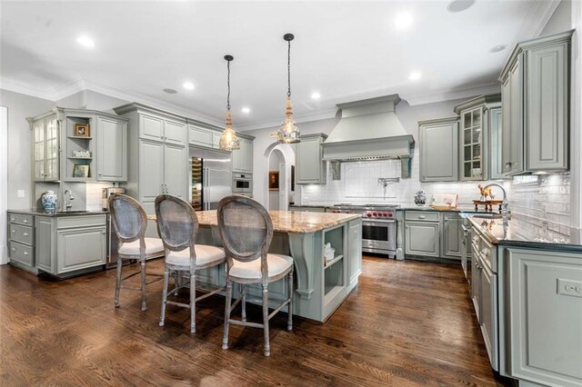 kitchen with custom range hood, open shelves, gray cabinetry, and premium appliances