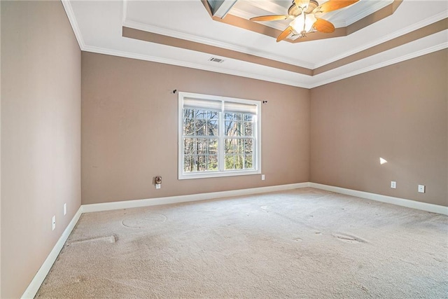 carpeted spare room with visible vents, a ceiling fan, baseboards, crown molding, and a raised ceiling