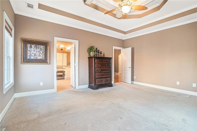 unfurnished bedroom with visible vents, light colored carpet, baseboards, and a tray ceiling