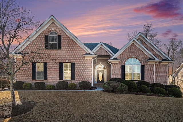 traditional-style house with a yard and brick siding