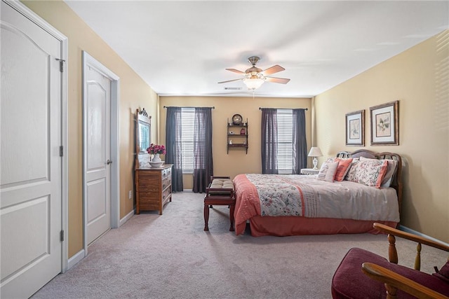 bedroom featuring light carpet, visible vents, a ceiling fan, and baseboards