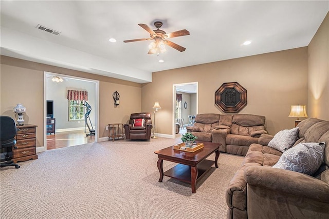 carpeted living area featuring recessed lighting, visible vents, baseboards, and a ceiling fan