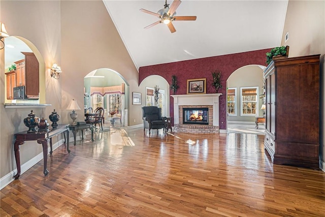 living area featuring a fireplace, wood finished floors, and baseboards