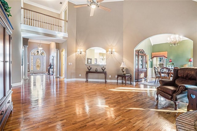 living area featuring arched walkways, baseboards, and wood finished floors