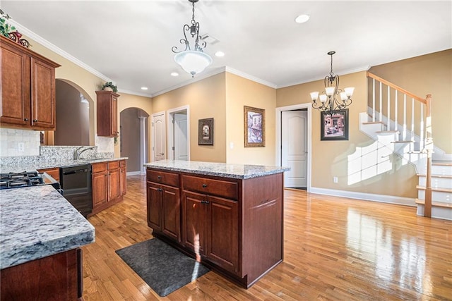 kitchen featuring light wood finished floors, a kitchen island, arched walkways, black dishwasher, and backsplash