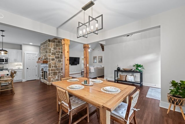 300 Olde Wick Trl, Hoschton, GA 30548 - dining space with decorative columns, dark wood-style flooring, baseboards, a fireplace, and a chandelier