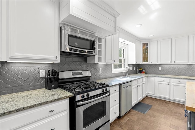 75 Auburn Rd, Auburn, GA 30011 - kitchen featuring stainless steel appliances, a sink, white cabinets, backsplash, and glass insert cabinets