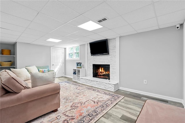 75 Auburn Rd, Auburn, GA 30011 - living area featuring wood finished floors, a fireplace, baseboards, and a paneled ceiling