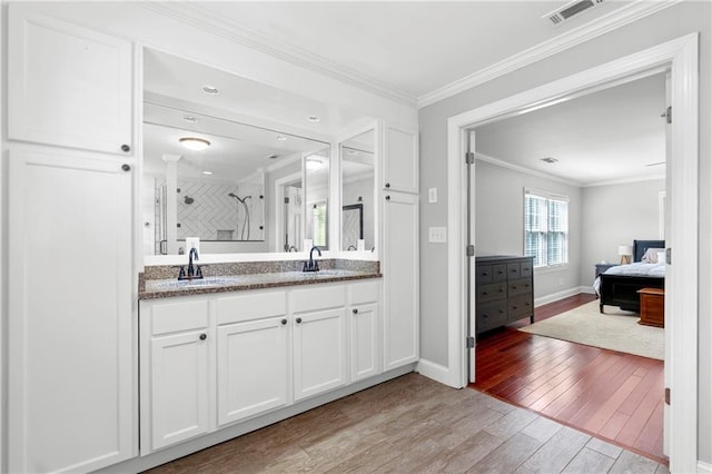75 Auburn Rd, Auburn, GA 30011 - bathroom featuring wood finished floors, double vanity, a shower stall, baseboards, and ornamental molding