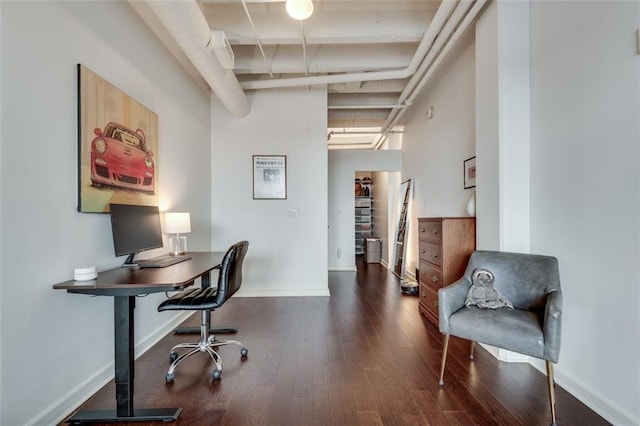 home office with beamed ceiling and dark hardwood / wood-style flooring