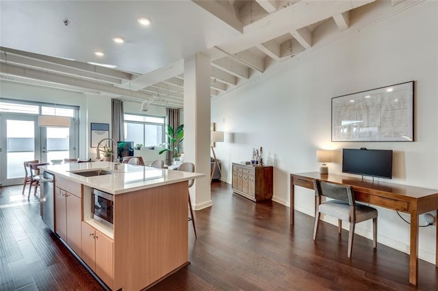 kitchen with a kitchen island with sink, sink, dark hardwood / wood-style floors, and appliances with stainless steel finishes