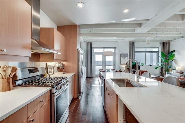 kitchen with sink, light stone counters, dark hardwood / wood-style floors, stainless steel appliances, and wall chimney range hood