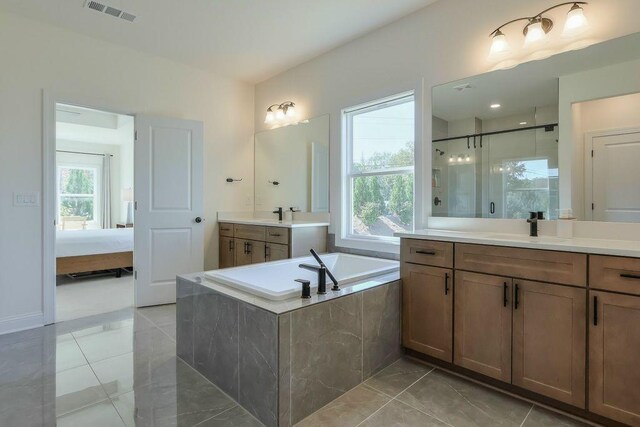 bathroom featuring vanity, a wealth of natural light, tile patterned flooring, and separate shower and tub