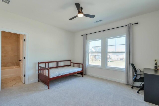 carpeted bedroom featuring ceiling fan and ensuite bath