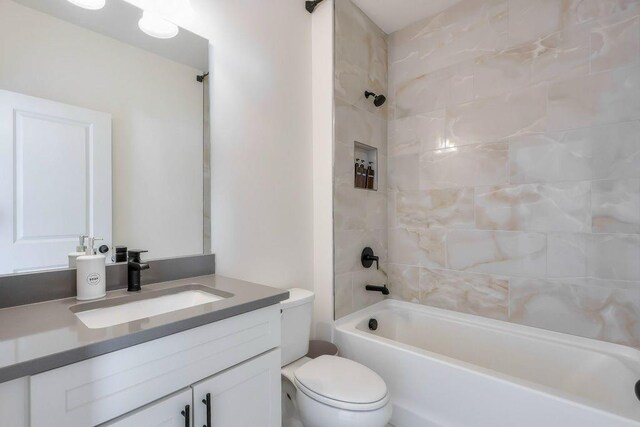 full bathroom with vanity, toilet, and tiled shower / bath combo