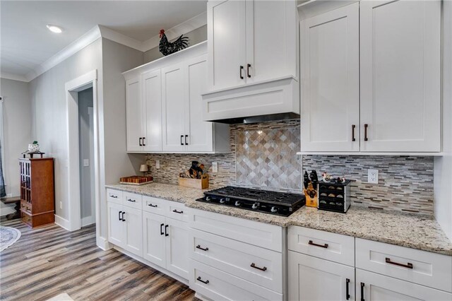 340 Taylor Path, Dallas, GA 30157 - kitchen with black gas stovetop, light wood-type flooring, white cabinets, ornamental molding, and extractor fan