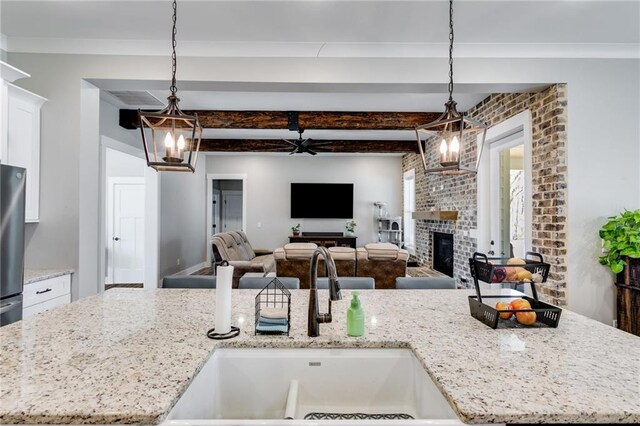 340 Taylor Path, Dallas, GA 30157 - kitchen with beam ceiling, a sink, freestanding refrigerator, white cabinetry, and light stone countertops