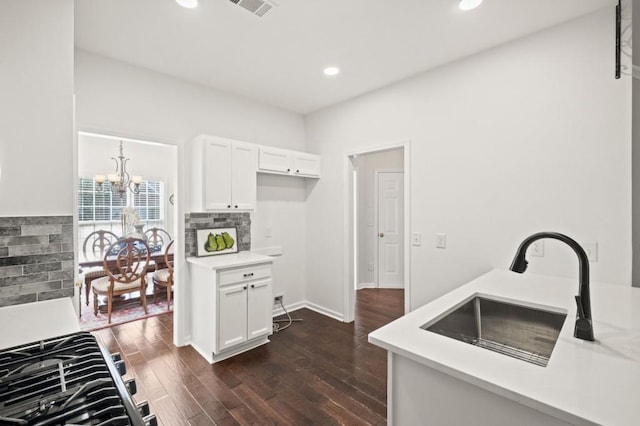 kitchen featuring white cabinets, dark wood-type flooring, sink, and a chandelier