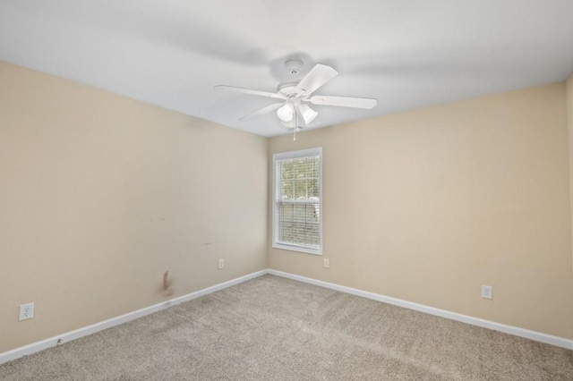 carpeted spare room featuring ceiling fan