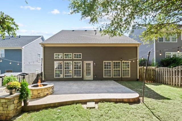 back of property featuring a lawn, a patio area, and a fire pit