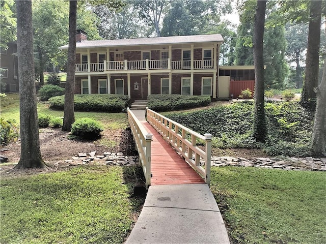 back of property featuring a yard and a balcony