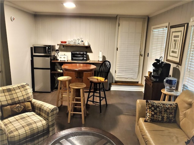 kitchen with appliances with stainless steel finishes, dark hardwood / wood-style flooring, and ornamental molding