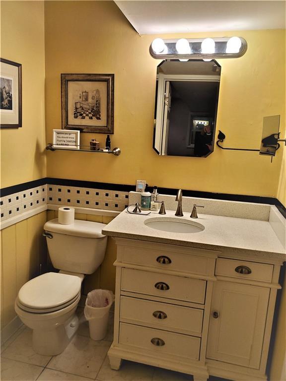 bathroom featuring toilet, tile floors, and vanity