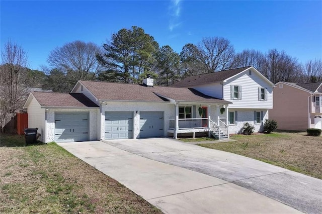 view of front of house featuring a garage, driveway, a porch, and a front yard